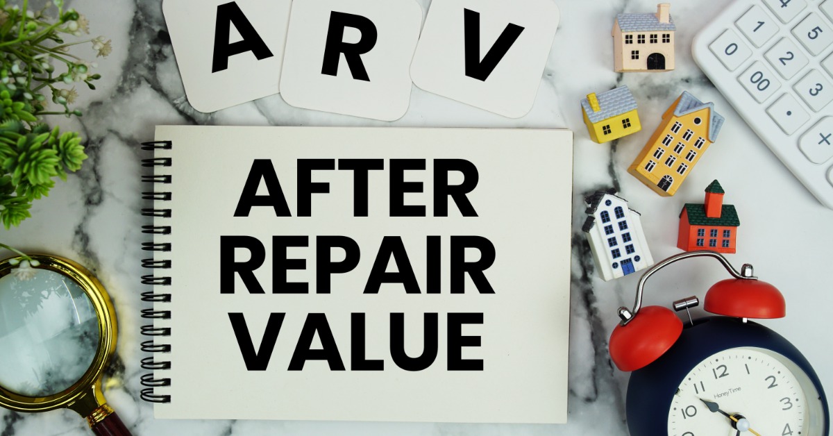 A spiral notebook with the words "after repair value" and ARV letters with small home models and a magnifying glass.