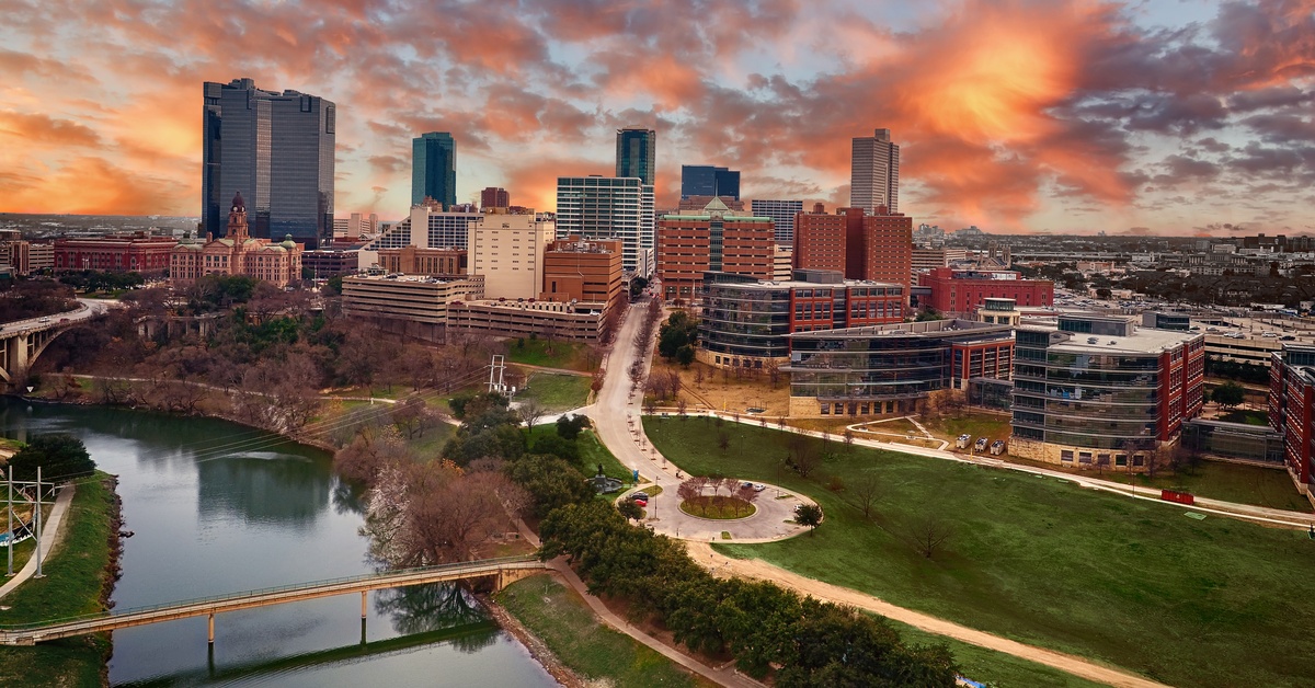 An aerial view of downtown Fort Worth, Texas, showing many of the large buildings and a river running through.